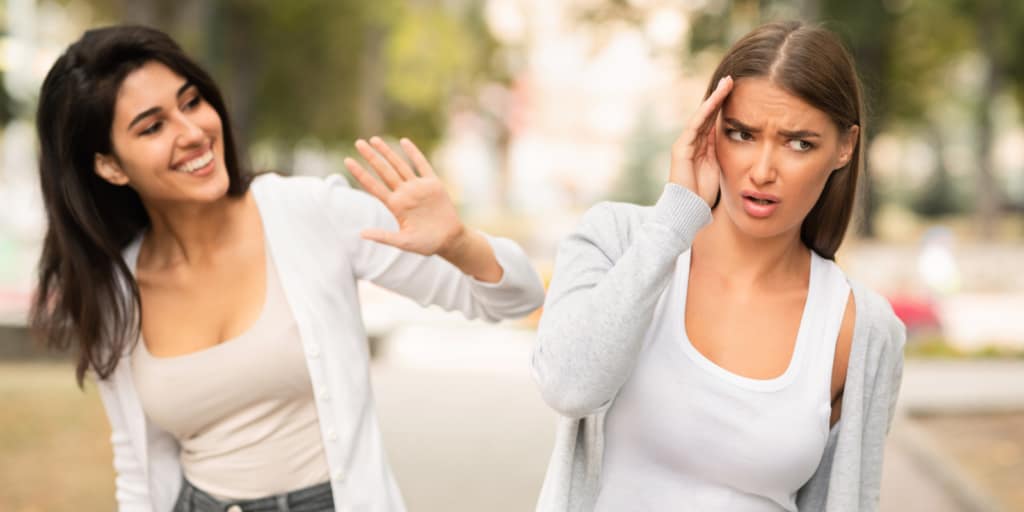 Two women pushing each other away in a pattern of avoidance